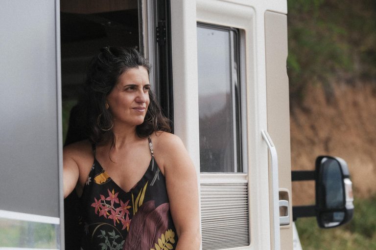 Laia Balmes asomada a la puerta de una autocaravana, mirando al horizonte